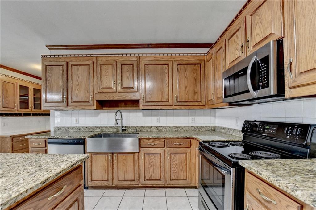 1622 New Hope Road Lawrenceville, GA 30045 - Photo 27 of 110 a kitchen with stainless steel appliances granite countertop a stove top oven a sink dishwasher and cabinets with wooden floor
