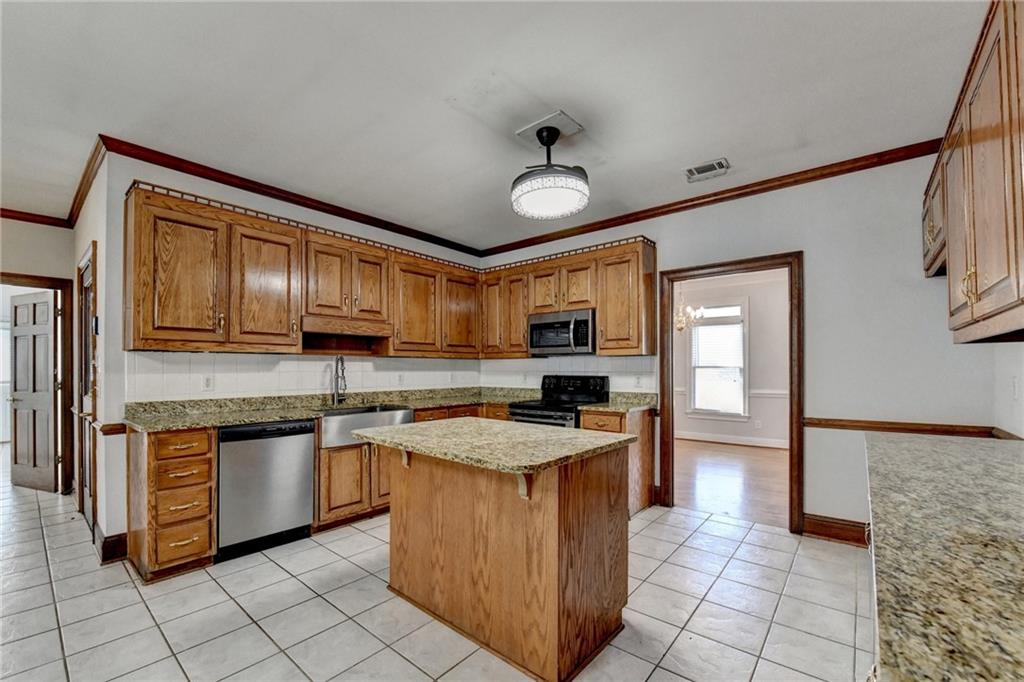 1622 New Hope Road Lawrenceville, GA 30045 - Photo 33 of 110 a kitchen with stainless steel appliances granite countertop a stove top oven a sink a counter top space and cabinets