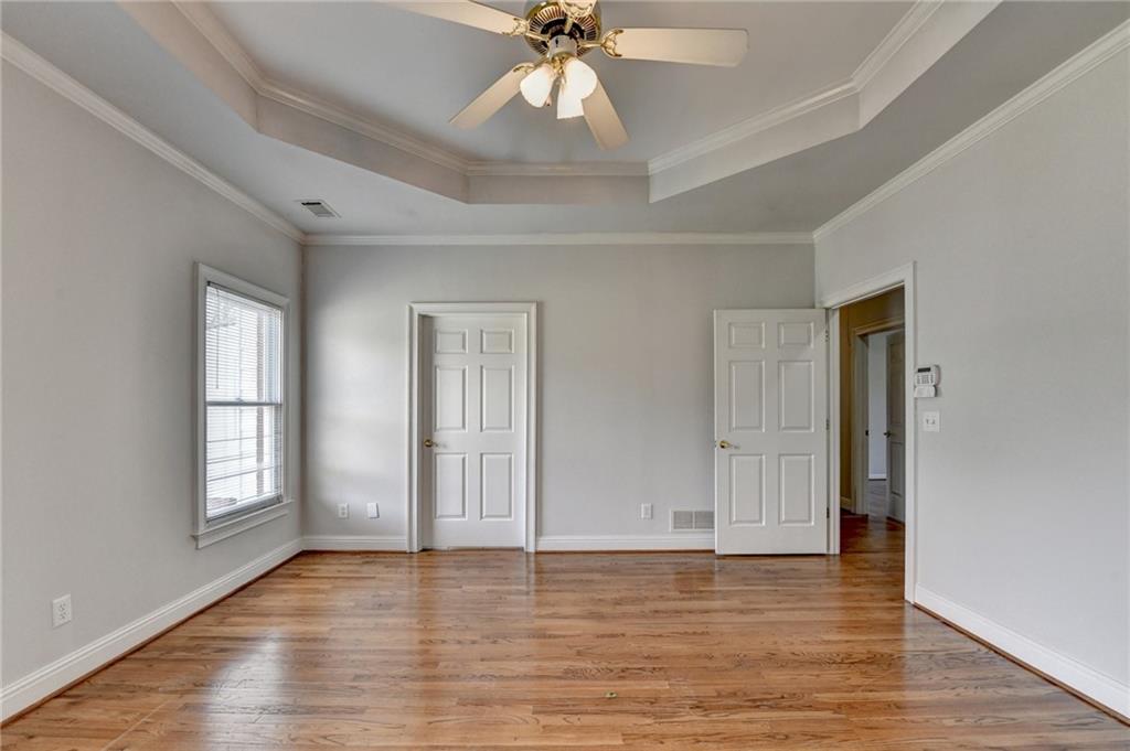 1622 New Hope Road Lawrenceville, GA 30045 - Photo 48 of 110 an empty room with wooden floor chandelier fan and windows