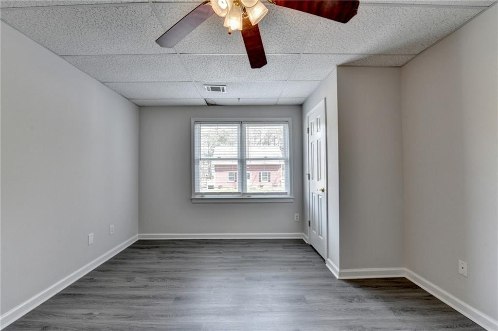 1622 New Hope Road Lawrenceville, GA 30045 - Photo 73 of 110 an empty room with wooden floor ceiling fan and windows