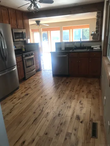 a kitchen with wooden floors and stainless steel appliances