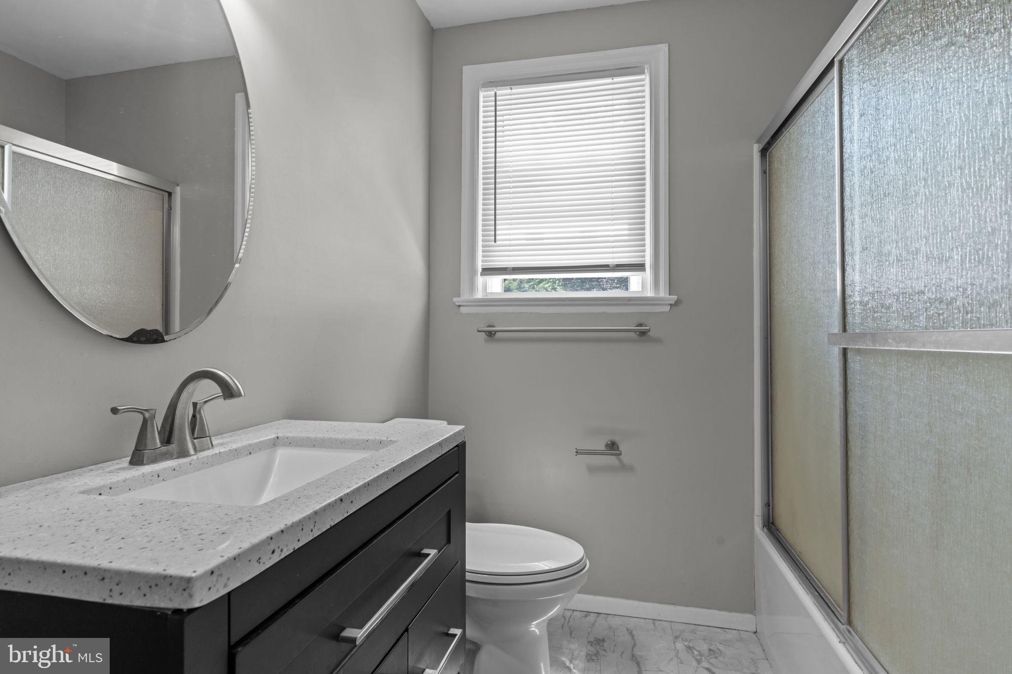 339 Pitman Avenue Pitman, NJ 08071 - Photo 13 of 25 a bathroom with a granite countertop toilet a sink and a mirror