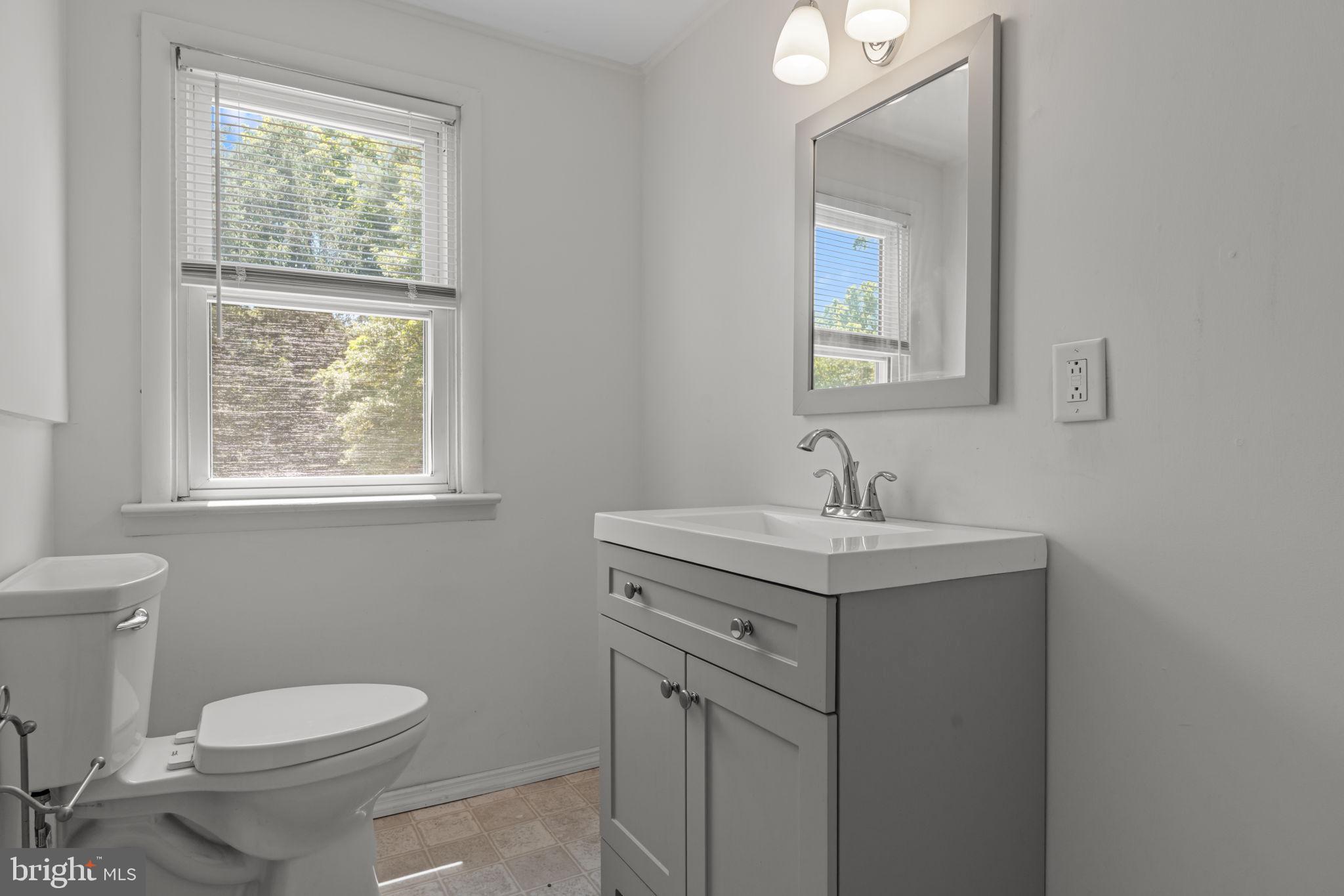 339 Pitman Avenue Pitman, NJ 08071 - Photo 16 of 25 a bathroom with a toilet a sink a window and mirror