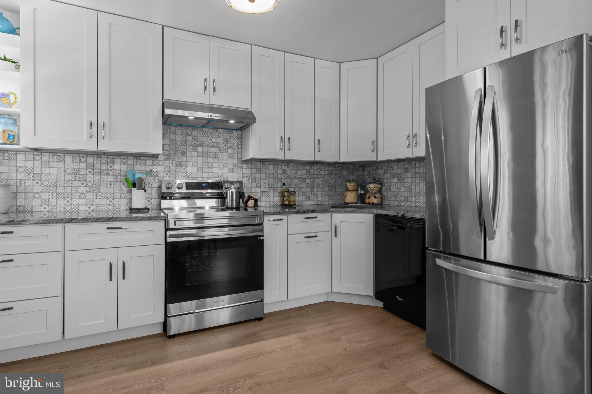 339 Pitman Avenue Pitman, NJ 08071 - Photo 8 of 25 a kitchen with stainless steel appliances white cabinets white stove a refrigerator and a granite counter tops