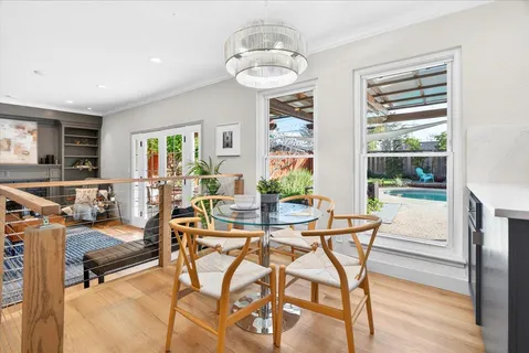 a dining room with furniture a chandelier and wooden floor