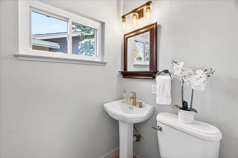 a bathroom with a toilet sink and mirror