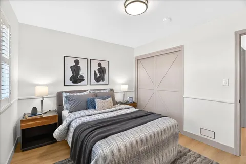 a bedroom with a bed and painting on the wall