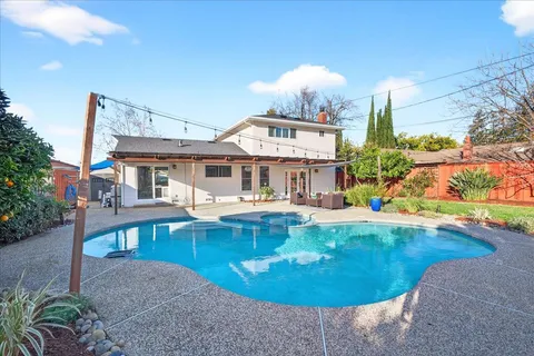 a view of a house with swimming pool and sitting area