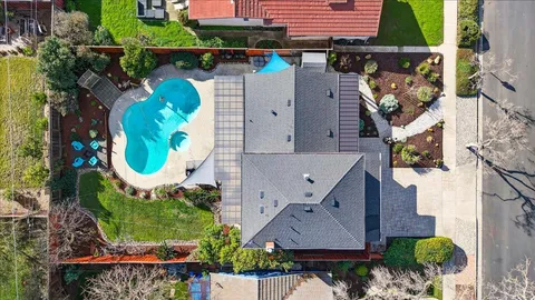 an aerial view of a house with a yard and lake view