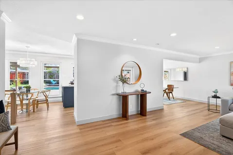 a living room with furniture a dining table and wooden floor
