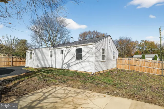 a view of a house with backyard and trees