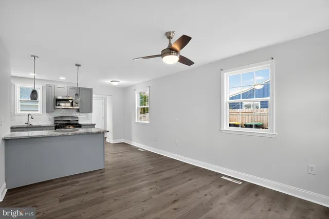a kitchen with stainless steel appliances kitchen island wooden floors and white cabinets