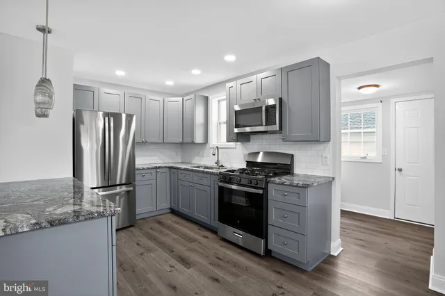 a kitchen with stainless steel appliances granite countertop a refrigerator stove and microwave