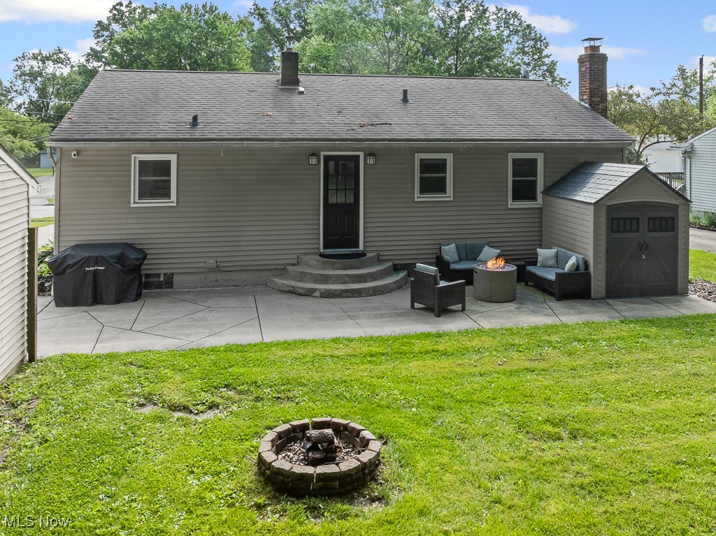 4000 Kenneth Road Stow, OH 44224 - Photo 48 of 50 Back of house with an outdoor living space with a fire pit, a yard, a storage shed, a patio, and a chimney