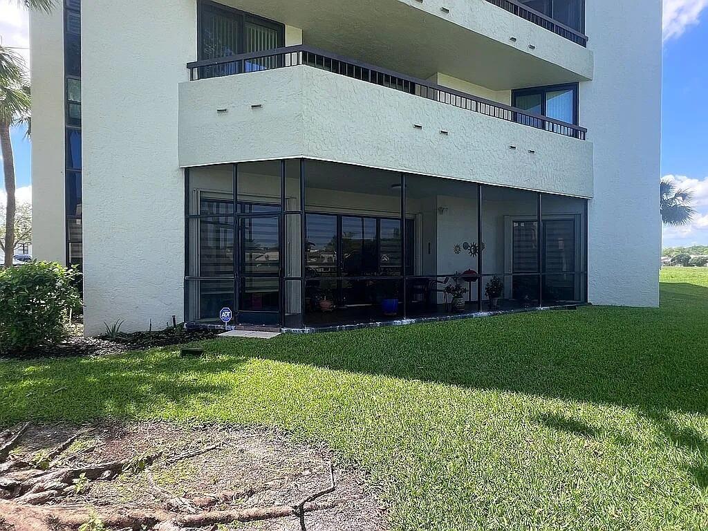 6463 La Costa Drive, Unit 105 Boca Raton, FL 33433 - Photo 35 of 40 a front view of a house with a yard and garage
