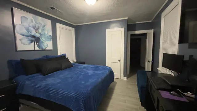 a bedroom with a bed and a flat screen tv
