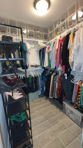 a view of walk in closet with clothes and shoes
