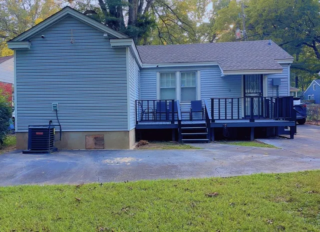 a view of a house with a yard and furniture