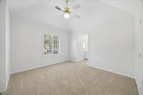 an empty room with fan and windows
