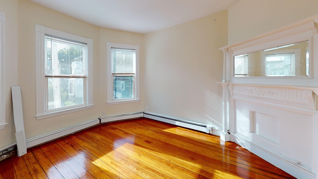 7 Sunset Street, Unit UPPR Boston, MA 02120 - Photo 3 of 7 a view of empty room with wooden floor and fan