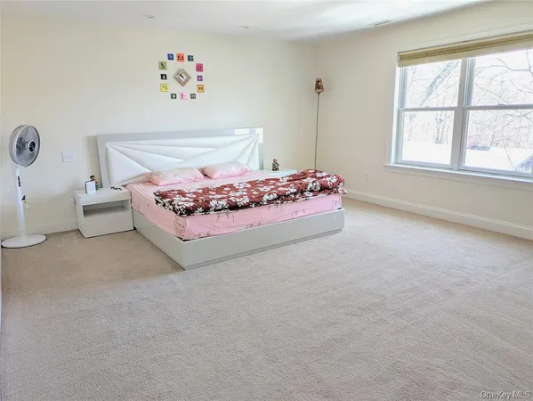 a bedroom with a bed and a large window