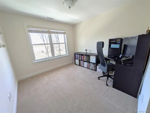a view of a workspace with furniture and a window