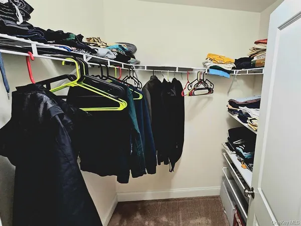 a view of walk in closet with clothes and shoes
