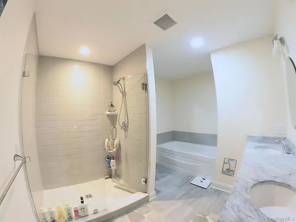 a bathroom with a tub a toilet and a shower