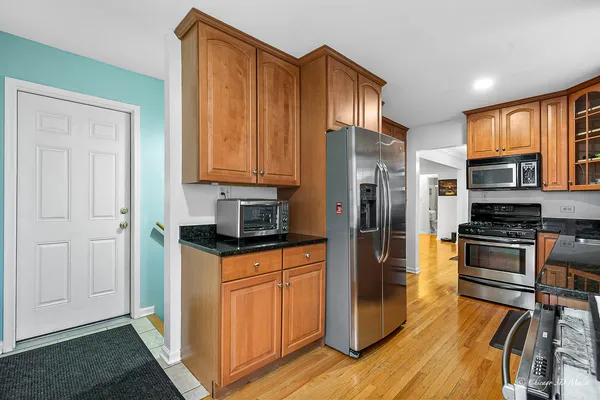 a kitchen with stainless steel appliances granite countertop a refrigerator and a stove top oven