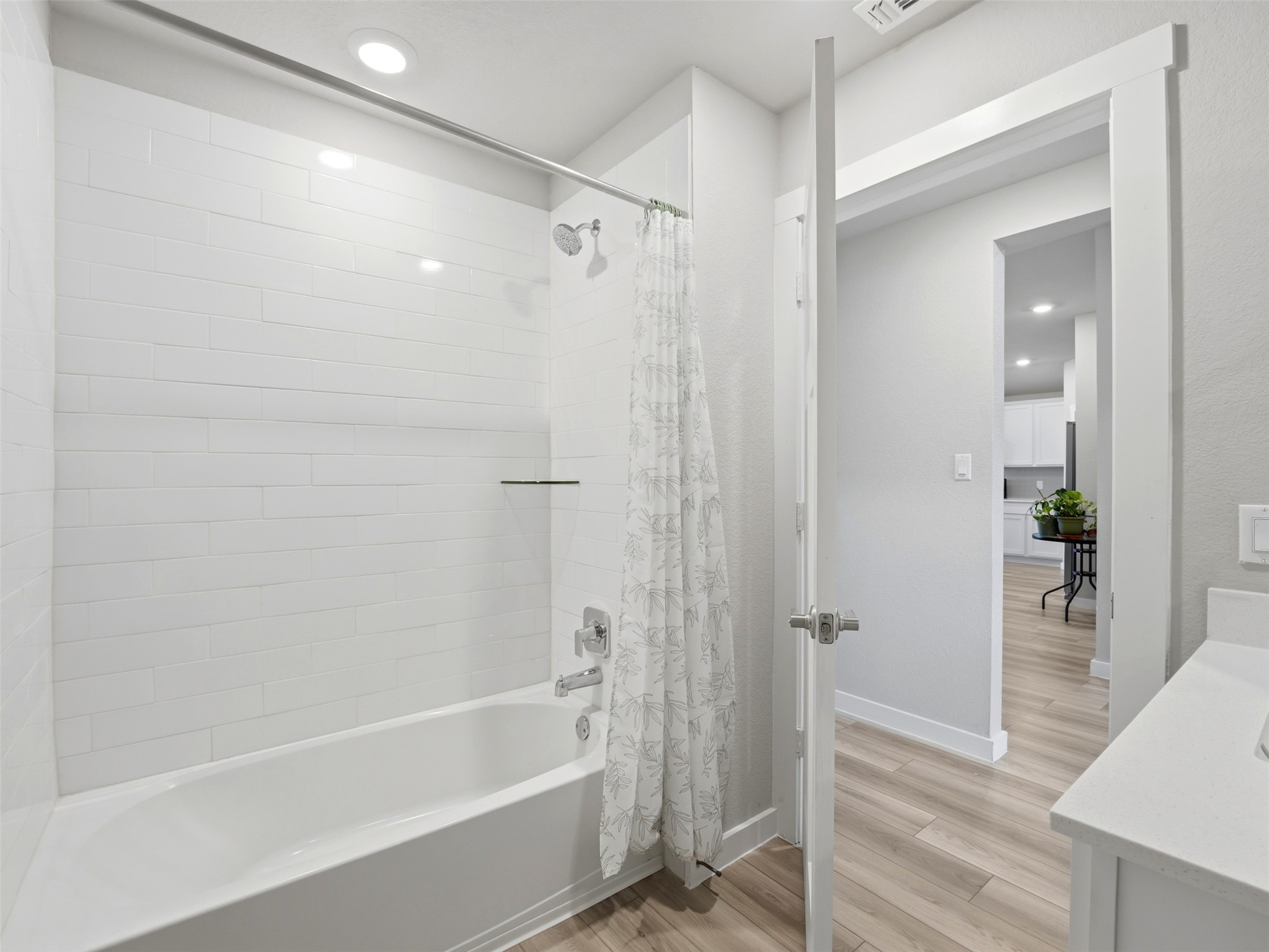 1024 Tipton Street Georgetown, TX 78633 - Photo 20 of 32 A well-appointed bath features a tiled shower/tub combination and ample light wood-look flooring.