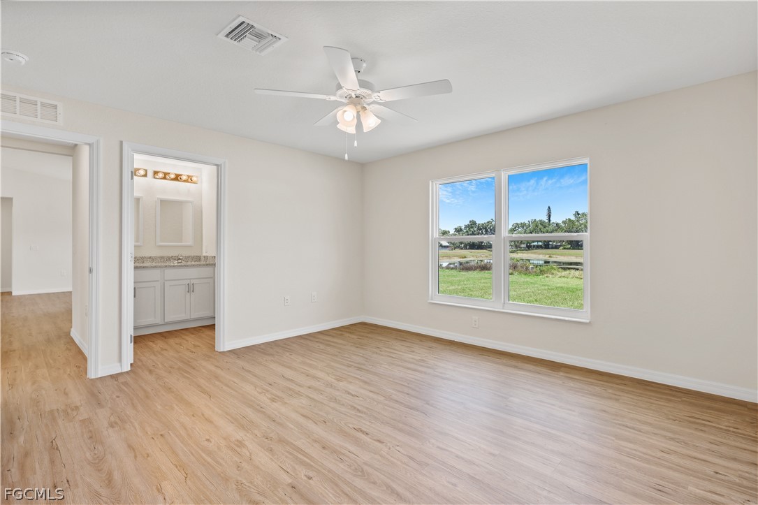 4524 Springview Circle LaBelle, FL 33935 - Photo 14 of 25 an empty room with wooden floor fan and windows