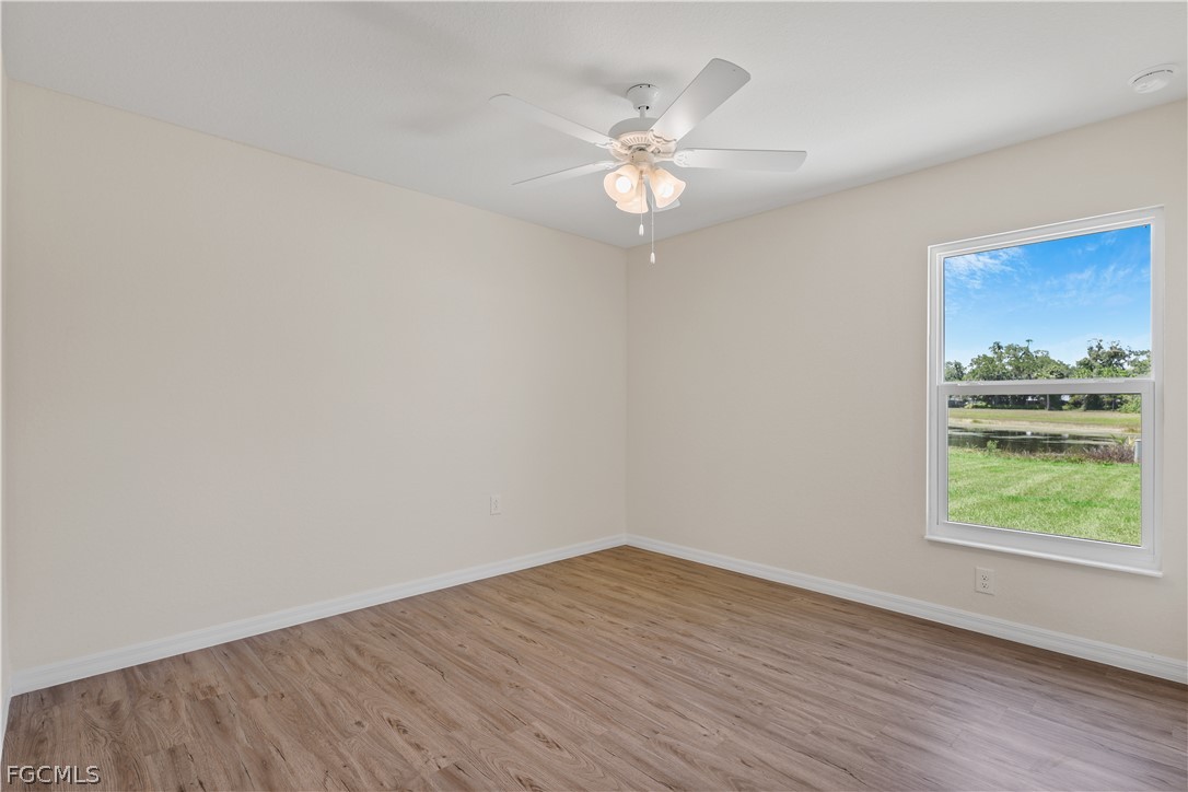 4524 Springview Circle LaBelle, FL 33935 - Photo 16 of 25 an empty room with wooden floor fan and windows