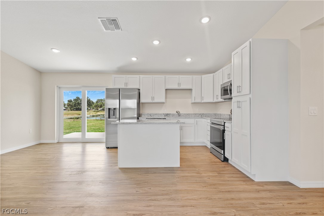 4524 Springview Circle LaBelle, FL 33935 - Photo 7 of 25 a kitchen with white cabinets and white appliances