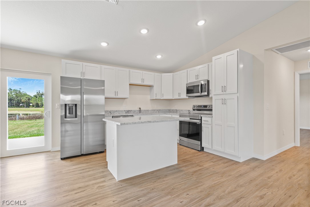 4524 Springview Circle LaBelle, FL 33935 - Photo 8 of 25 a kitchen with a refrigerator a stove top oven and kitchen island