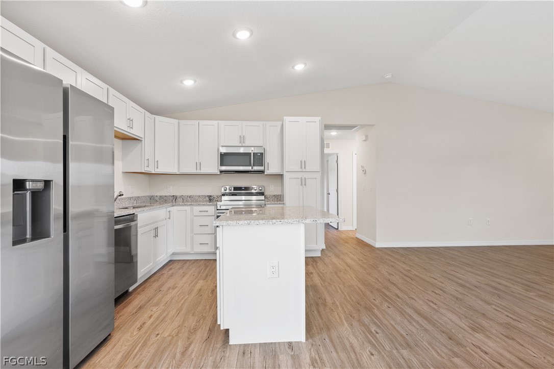 4524 Springview Circle LaBelle, FL 33935 - Photo 10 of 25 a kitchen with a refrigerator a stove top oven and wooden floors