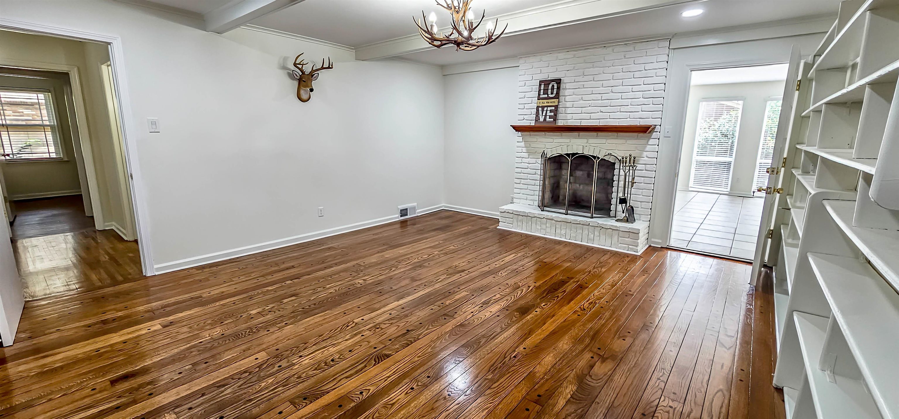 5639 Glade View Drive Memphis, TN 38120 - Photo 12 of 39 a view of an empty room with wooden floor fireplace and a window