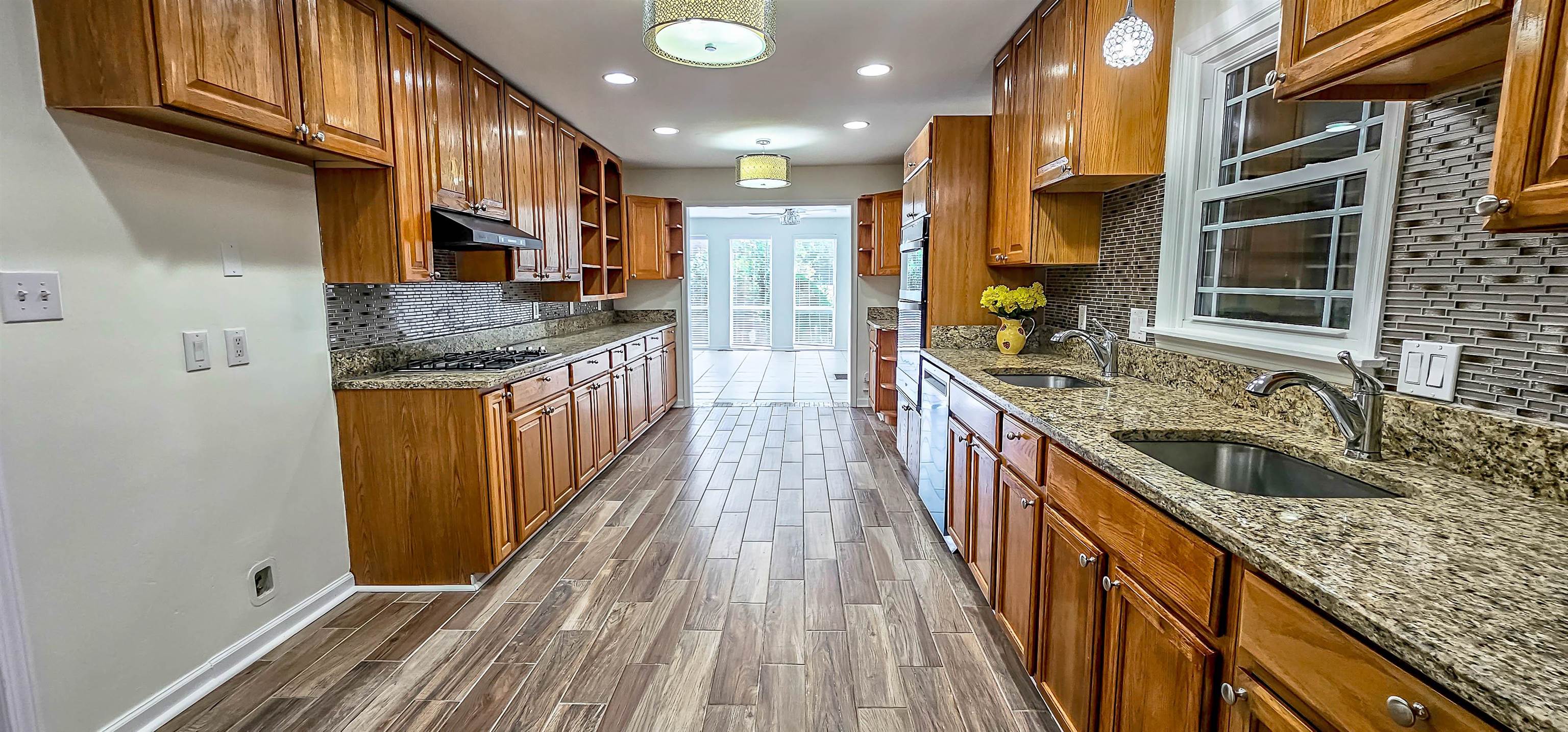 5639 Glade View Drive Memphis, TN 38120 - Photo 14 of 39 a kitchen with stainless steel appliances granite countertop a sink a stove and a wooden floors