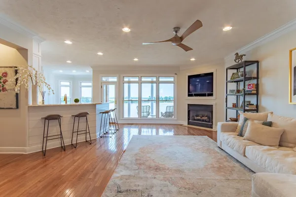 a living room with fireplace furniture and a large window