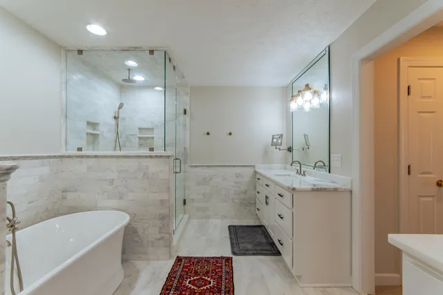 a bathroom with a tub sink and mirror