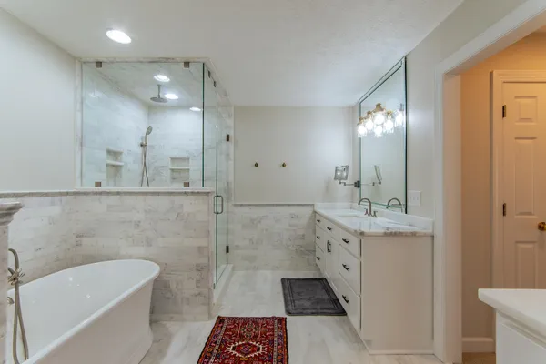 a bathroom with a tub sink and mirror