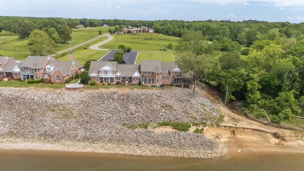an aerial view of a house with a yard and lake view