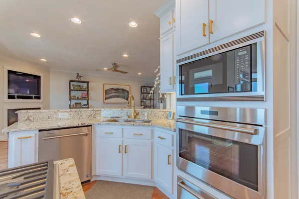 a kitchen with granite countertop cabinets stainless steel appliances and a counter space