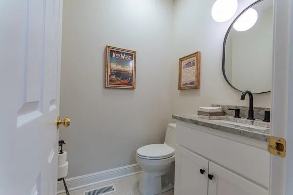 a bathroom with a granite countertop toilet sink and mirror
