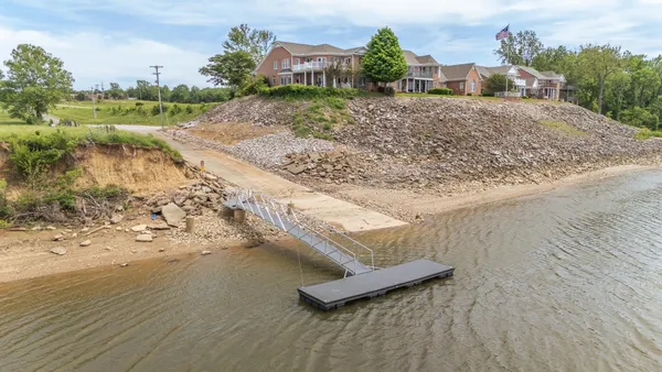 a view of a dry yard with wooden fence