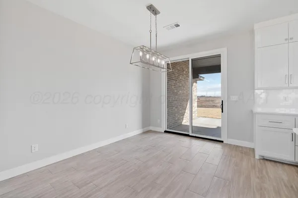 a view of a kitchen with white cabinets and a wooden floor