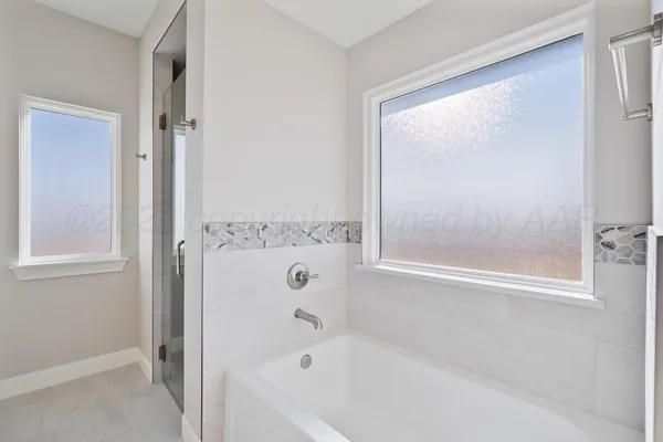 a bathroom with a tub sink and mirror