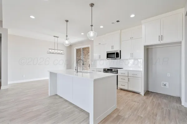 a large white kitchen with cabinets