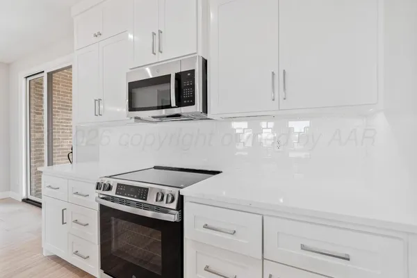 a kitchen with stainless steel appliances white cabinets and a stove