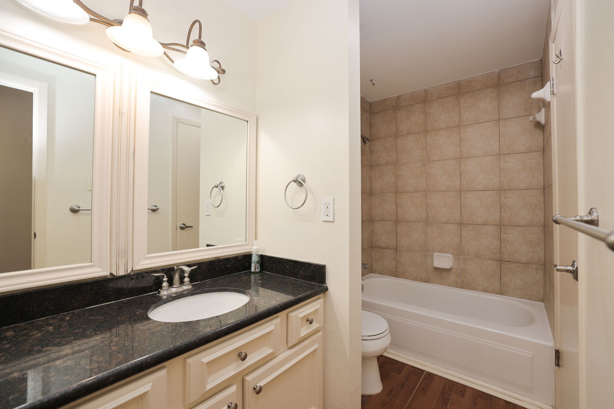 2001 Bering Drive, Unit 2F Houston, TX 77057 - Photo 17 of 32 a bathroom with a granite countertop sink toilet a large mirror a bathtub and shower
