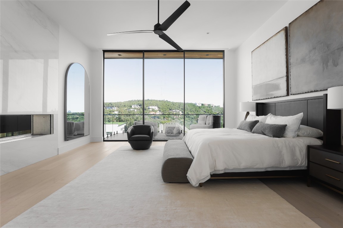 1003 The High Road Austin, TX 78746 - Photo 20 of 40 a spacious bedroom with bed and a large window